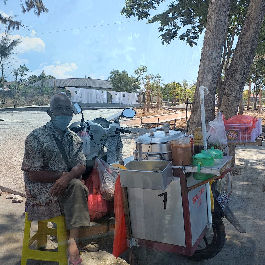 Penjual pentolan keliling, Marjuki sedang menunggu pembeli di Taman Tagape, Kecamatan Kelapa Lima, Kota Kupang, Jumat, 13 Agustus 2021. (Fa-KatongNTT)