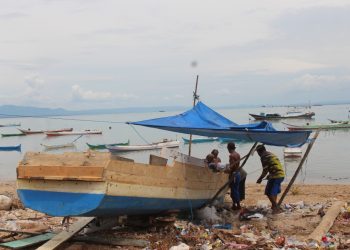 Nelayan pesisir di Sulama, Kabupaten Kupang sedang memperbaiki perahu yang sedang rusak (Mariano Lejap-Yayasan Pikul)