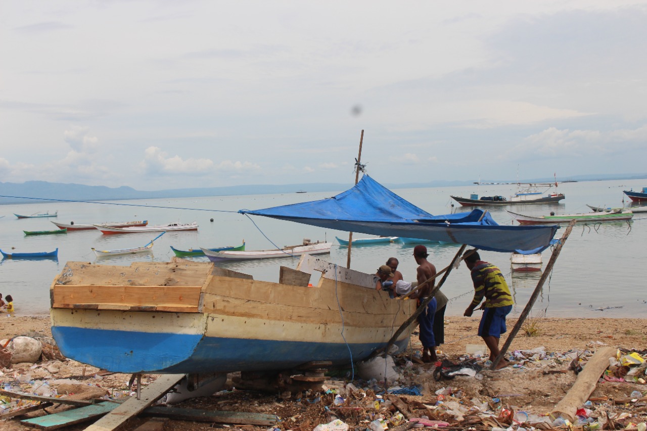 Nelayan pesisir di Sulama, Kabupaten Kupang sedang memperbaiki perahu yang sedang rusak (Mariano Lejap-Yayasan Pikul)