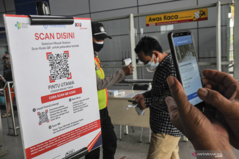 Ilustrasi - Petugas (kiri) mensosialisasikan kepada calon penumpang KRL (Kereta Rel Listrik) untuk memindai QR Code sebelum memasuki peron Stasiun Bekasi Timur, Jawa Barat, Selasa (7/9/2021). (ANTARA FOTO/ Fakhri Hermansyah/foc)