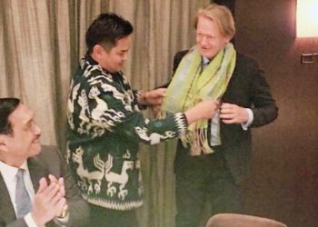 Ketua KADIN NTT, Bobby Lianto mengalungkan kain tenun NTT kepada CEO BloombergNEF, Jhon Moore disaksikan Menko Marves, Luhut Binsar Pandjaitan (dok. KADIN NTT)