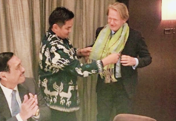 Ketua KADIN NTT, Bobby Lianto mengalungkan kain tenun NTT kepada CEO BloombergNEF, Jhon Moore disaksikan Menko Marves, Luhut Binsar Pandjaitan (dok. KADIN NTT)