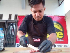 Nyongki Manufoe sedang memotong daging sapi untuk diolah menjadi sei sapi Oparote di rumah produksinya di kawasan Pasir Panjang, Kota Kupang, NTT, Kamis, 26 Januari 2023. (Gega Making-KatongNTT.com)