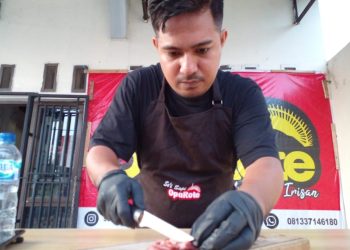 Nyongki Manufoe sedang memotong daging sapi untuk diolah menjadi sei sapi Oparote di rumah produksinya di kawasan Pasir Panjang, Kota Kupang, NTT, Kamis, 26 Januari 2023. (Gega Making-KatongNTT.com)