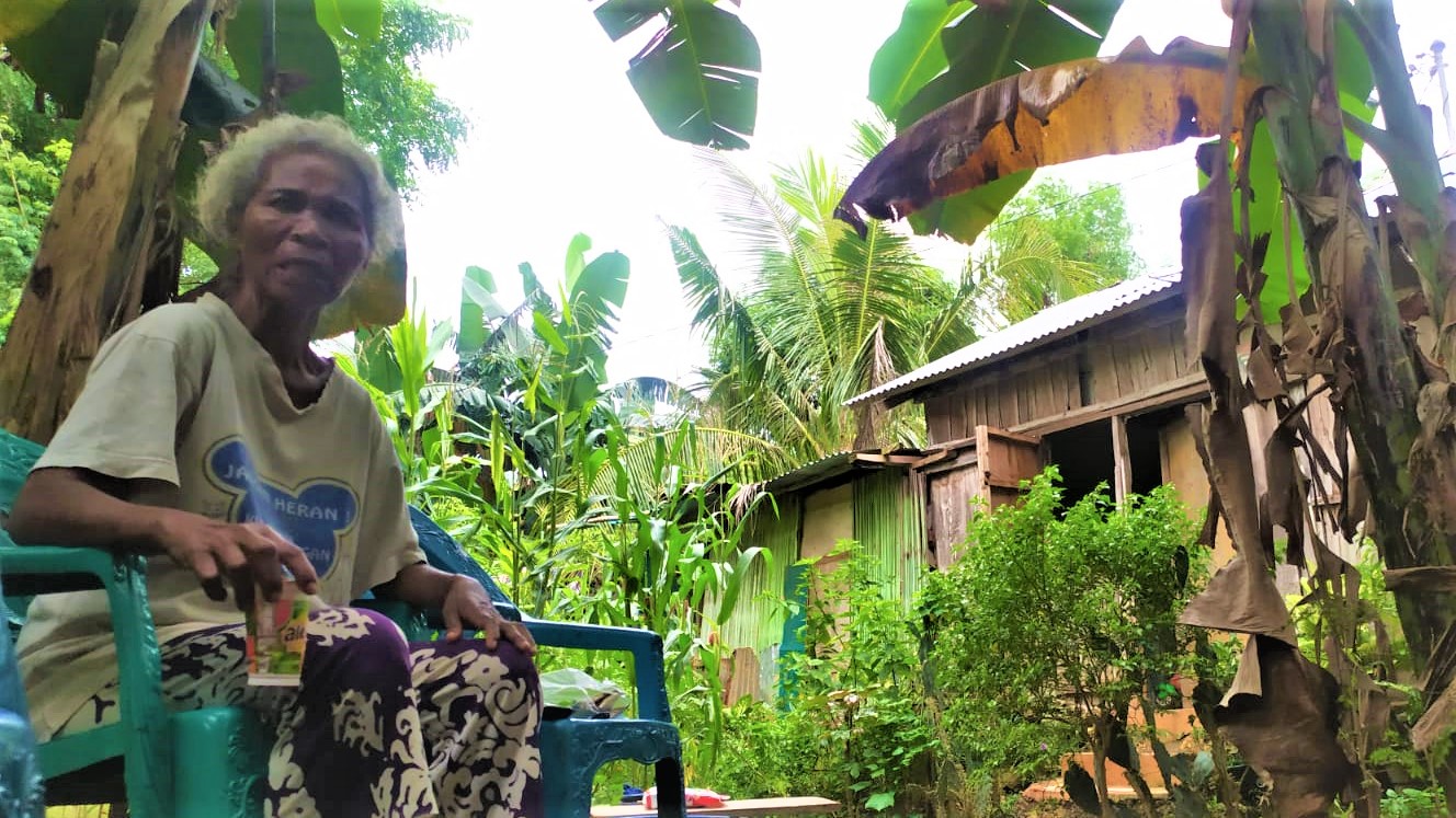 Mama Peni di depan rumahnya yang dibangun di atas lahan seorang pengusaha di Kelurahan Belo, Kota Kupang, NTT. (Gega Making - KatongNTT.com)