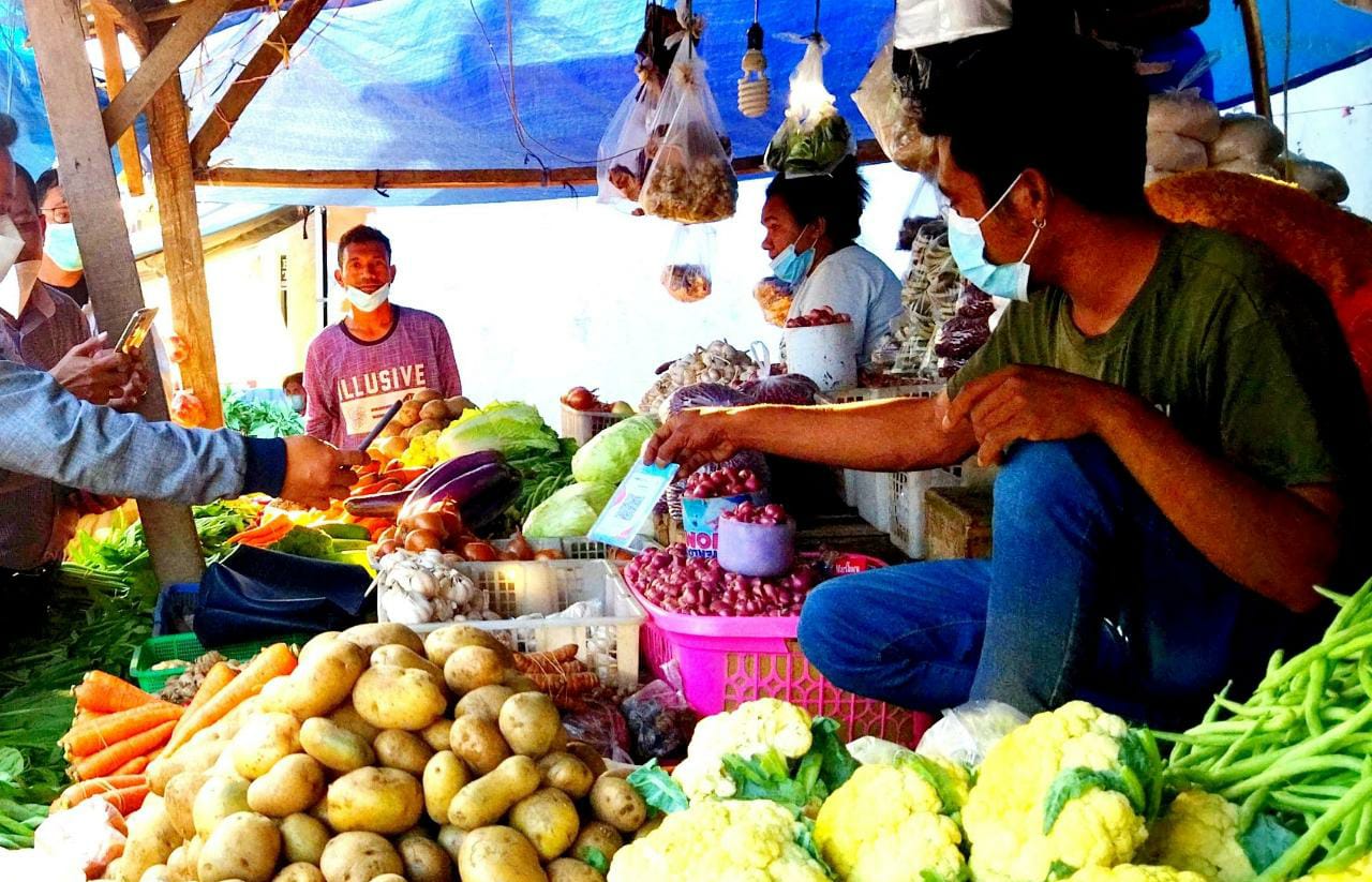 Seorang pedagang di Pasar Kasih Naikoten I Kota Kupang menerima pembayaran melalui merchant QRIS, Agustus 2021 (Putra Bali Mula - KatongNTT.com)