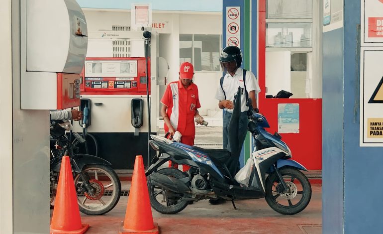 Petugas SPBU Oeba Kota Kupang sedang mengisi Pertalite ke sepeda motor konsumen. (Putra Bali Mula - KatongNTT.com)