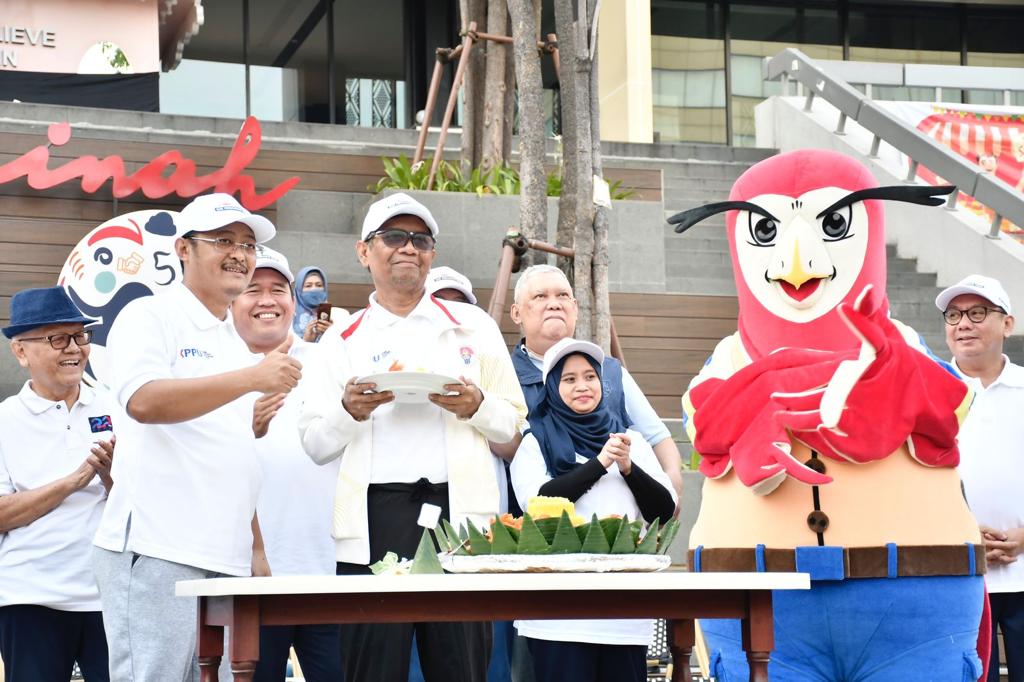 Ketua KPPU M.Afif Hasbullah (kiri, mengenakan kaus putih) dan Menkopolhukham Mahfud MD mendeklarasikan tanggal 5 Maret sebagai Hari Persaingan Usaha. Pendeklarasian diadakan di lokasi hari bebas kendaraan di Jakarta, Minggu, 11 Juni 2023. (Dok.KPPU)