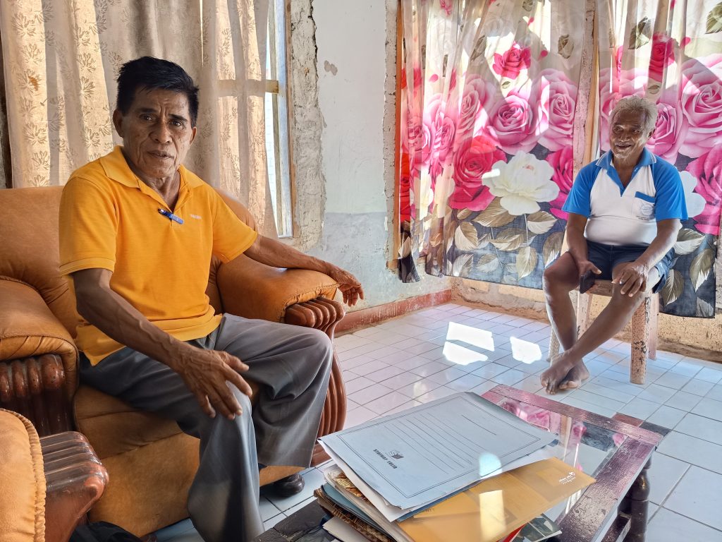 Mantan Ketua BPD Desa Tablolong, Zakarias DoroH (baju oranye) dan Melliaki Keo, pembudidaya rumput laut menjelaskan dokumen laporan pertanggungjawaban keuangan. (Rita Hasugian/KatongNTT)