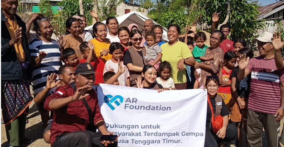 Julia Purmawati, pendiri AR Foundation (berdiri mengenakan kacamata menggendong anak) menyerahkan bantuan kemanusiaan kepada warga Desa Satar Padut, Kecamatan Lamba Leda Utara, Manggarai Timur pada Jumat, 29 Agustus 2026. (Dok. KatongNTT)